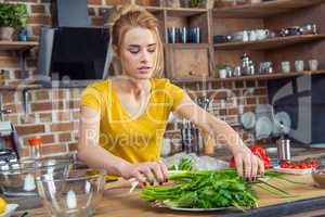 Woman holding green onions