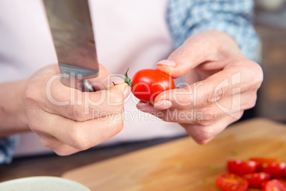 Woman holding knife and tomato