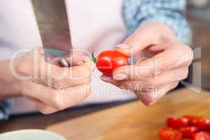 Woman holding knife and tomato