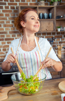 Woman mixing fresh vegetable salad