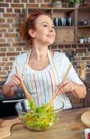 Woman mixing fresh vegetable salad