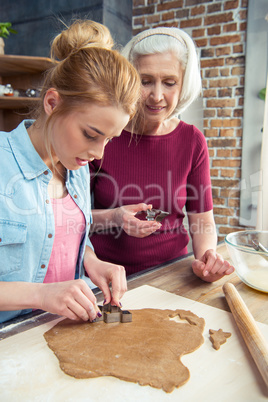 Grandmother and granddaughter making cookies