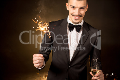 Handsome man holding sparkler