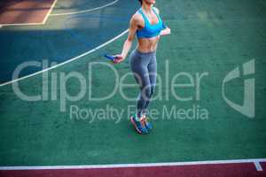 Athletic woman using jump rope