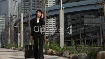 Slow Motion Asian Businesswoman Talking On Telephone Traveling With Baggage