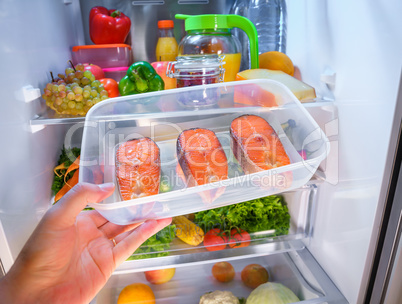 Raw Salmon steak in the open refrigerator