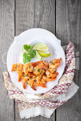 Fried Prawns with lemon placed on a wooden surface.