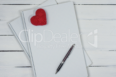Open notebook with a pen on a white wooden surface