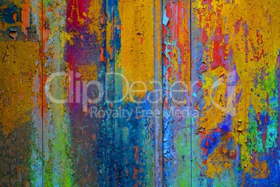 Holzwand mit abgeplatzter bunter Farbe gelb blau rot