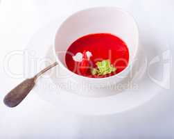 Strawberry soup with a spoon on a white background