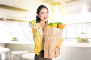 Asian woman holding groceries bag in kitchen