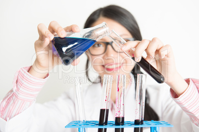 Young female scientist doing experiment in lab