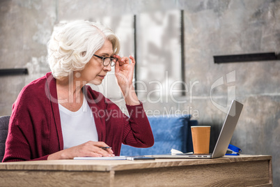 Senior woman adjusting eyeglasses