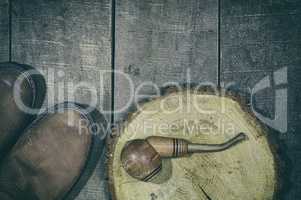 Wooden smoking pipe tobacco with a pair of leather boots