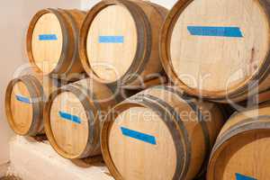 Wine Barrels and Bottles Age Inside Dark Cellar.