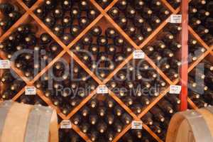 Several Varietal Wine Bottles and Barrels Age Inside Cellar