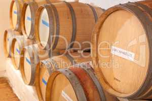Wine Barrels and Bottles Age Inside Dark Cellar.