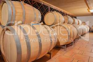 Wine Barrels and Bottles Age Inside Cellar