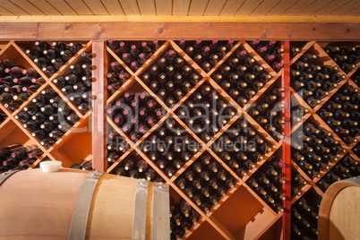 Wine Barrels and Bottles Age Inside Cellar