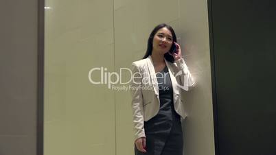 Attractive Asian Woman Talking On Mobile Telephone In Office Building.mov