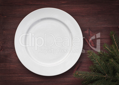 White empty plate on brown wooden surface