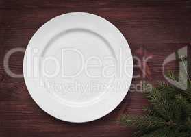 White empty plate on brown wooden surface