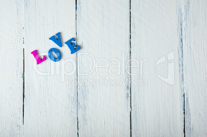 white wooden background with the word love in wooden letters