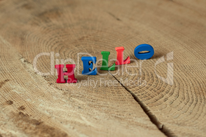 word hello from small wooden letters on a stump
