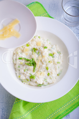 Risotto with Asparagus and cheese served on a table.