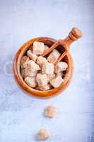 Brown cane sugar cubes in a wooden bowl