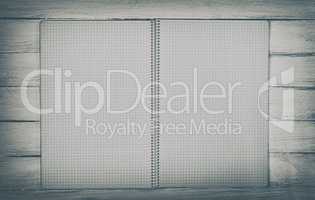 open notebook on a white wooden surface, top view
