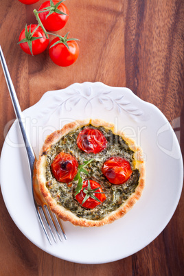 Mini Spinach Quiche with tomato served on a plate.