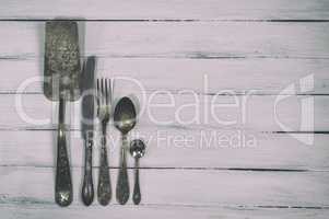Vintage cutlery on a white wooden background
