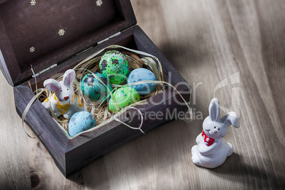 Easter bunny with colorful eggs in a box.