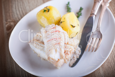 Steamed fish and potato on a plate served on plate.