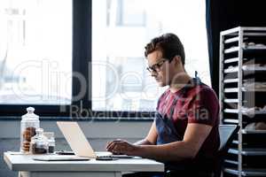Man working with laptop at bakery