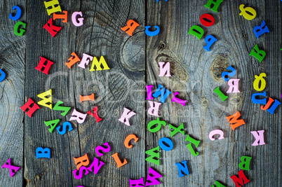 Multicolored little wooden letters on a gray surface