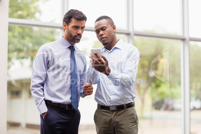 Business executives discussing over mobile phone