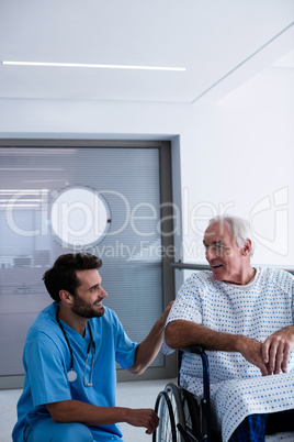 Doctor interacting with male senior patient on a wheelchair