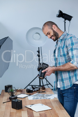 Male photographer reviewing captured photos in his digital camera