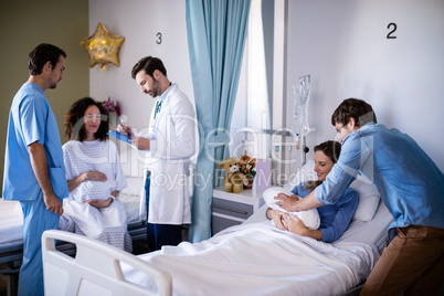 Couple with their newborn baby in the ward