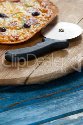 Italian pizza served on pizza tray with cutter