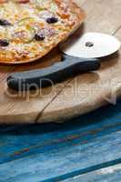 Italian pizza served on pizza tray with cutter