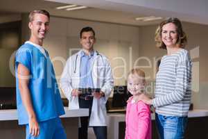 Portrait of doctors discussing medical report with mother and daughter