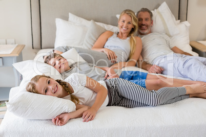 Parents and kids relaxing on bed in bedroom