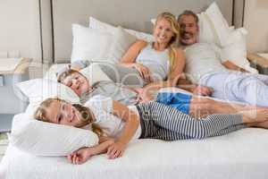 Parents and kids relaxing on bed in bedroom