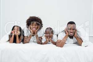 Portrait of parents and kids lying on bed