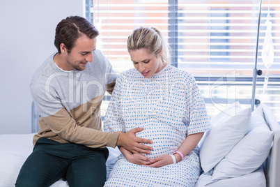 Man comforting pregnant woman in ward