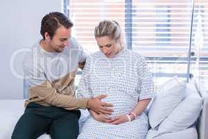Man comforting pregnant woman in ward