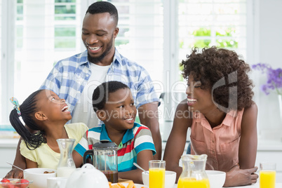 Kids and parents having breakfast on table at home